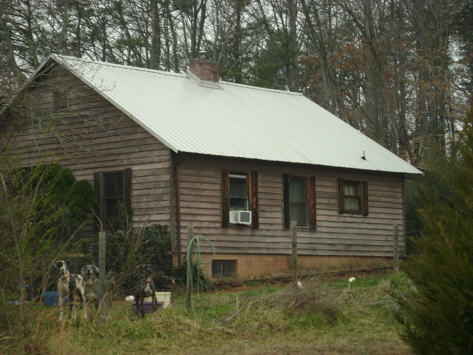 White metal roof on an old wood sided farmhouse, from a Metal Roof Installation job in Brookings